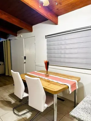 a dining room with a wooden table and white chairs at P and N Suites in Edmonton