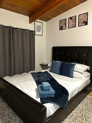 a bedroom with a large bed with a black headboard at P and N Suites in Edmonton