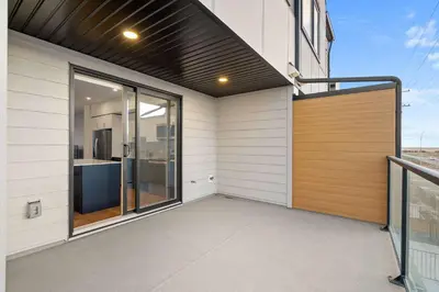 a balcony of a house with a wooden door at Skyline Retreat Spacious 4BR Home with Balcony! in Calgary
