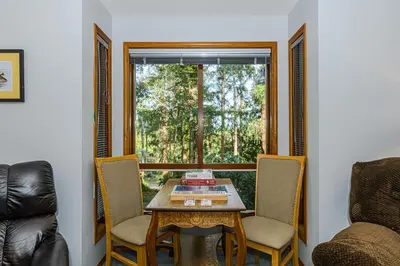 a room with a table and chairs and a window at Bayview Bed and Breakfast in Mill Bay