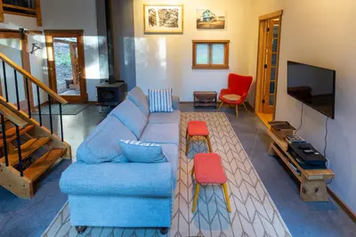 a living room with a blue couch and a tv at Jordan River Coastal Cottage in Shirley