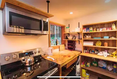a kitchen with a stove and a wooden counter top at Jordan River Coastal Cottage in Shirley