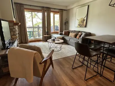 a living room with a couch and a table at Alpine at The Lodges of Canmore in Canmore