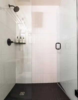 a bathroom with a shower with white tiles at Alpine at The Lodges of Canmore in Canmore