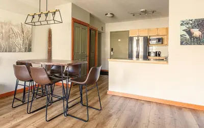 a kitchen with a table and chairs in a room at Alpine at The Lodges of Canmore in Canmore