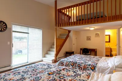 a bedroom with a king sized bed and a staircase at Fort Wine Manor, Entire Private Estate Home in Maple Ridge District Municipality
