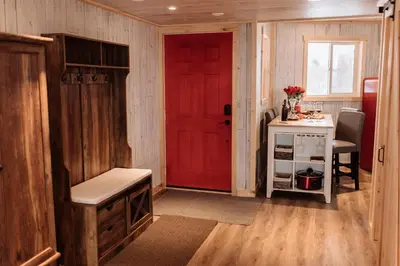 a red door in a room with a table and a desk at Quiet Country Cabin in Waiparous Village