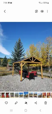 a picnic shelter with two red benches in a park at Quiet Country Cabin in Waiparous Village