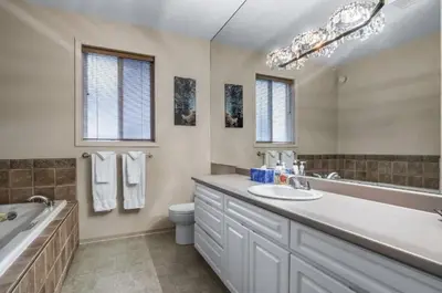 a bathroom with a tub and a toilet and a sink at The Marmot's Den in Sun Peaks