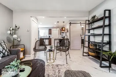 a living room with a couch and chairs and a kitchen at Park Life Escape-King Beds-Sleeps 10-Pet Friendly in Edmonton
