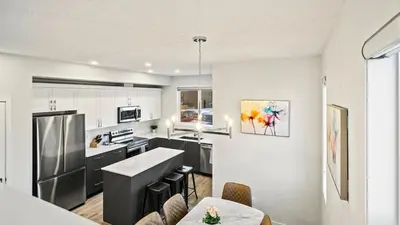 a kitchen with white cabinets and black appliances at A Home away from Home in Calgary