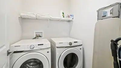 a laundry room with a washer and a washing machine at A Home away from Home in Calgary