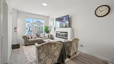 a living room with a couch and a clock on the wall at A Home away from Home in Calgary