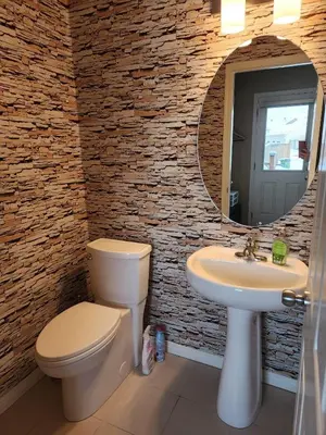 a bathroom with a toilet and a sink and a mirror at Cozy Luxury House in Edmonton