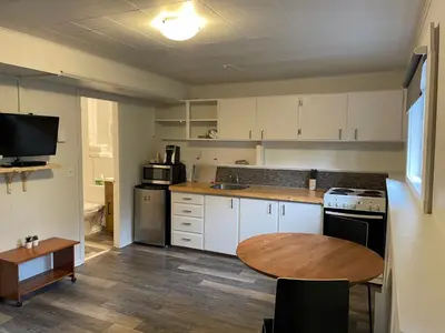 a kitchen with white cabinets and a wooden table at Pinewood Inn in Golden