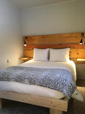a bedroom with a large bed with a wooden headboard at Pinewood Inn in Golden