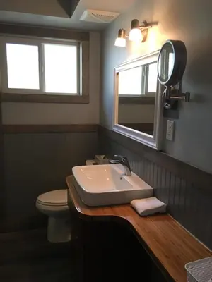 a bathroom with a sink and a toilet and a mirror at Pinewood Inn in Golden
