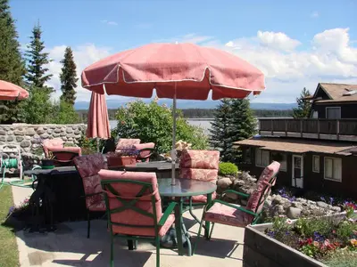 a table and chairs under an umbrella on a patio at Eagle's Nest Resort in Anahim Lake