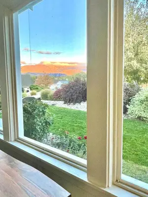 an open window with a view of a garden at Sandy beach Sauvignon cottage - Osoyoos escapade 3bd-2bt in Osoyoos
