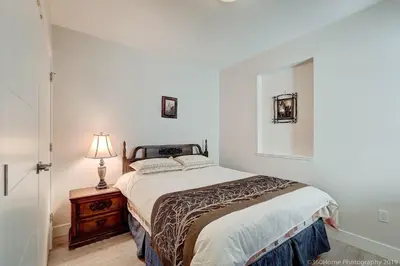 a bedroom with a bed and a lamp on a table at O Charming Bright Queen Bed Room Ensuite in West Vancouver