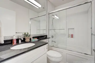 a white bathroom with a sink and a shower at O Charming Bright Queen Bed Room Ensuite in West Vancouver