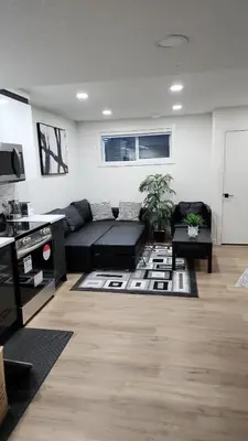 a living room with a black couch and a rug at Super luxury suite in Edmonton