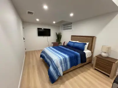 a bedroom with a bed and a flat screen tv at Midas Haven in Edmonton