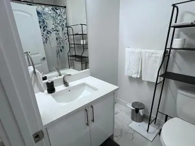 a white bathroom with a sink and a mirror at Midas Haven in Edmonton