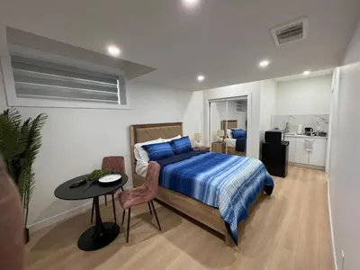 a bedroom with a bed and a table in it at Midas Haven in Edmonton