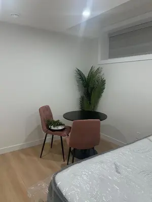 a room with a table and two chairs and a plant at Midas Haven in Edmonton