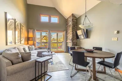 a living room with a couch and a table at Summit at The Lodges of Canmore in Canmore