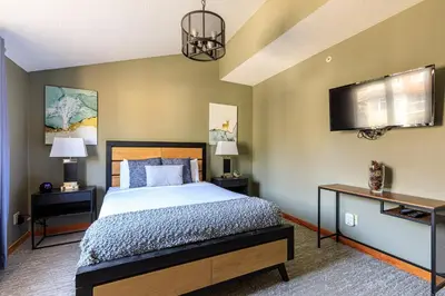 a bedroom with a bed and a flat screen tv at Summit at The Lodges of Canmore in Canmore