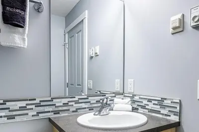 a bathroom with a sink and a mirror at Mountain Memories Family Fun at The Lodges in Canmore
