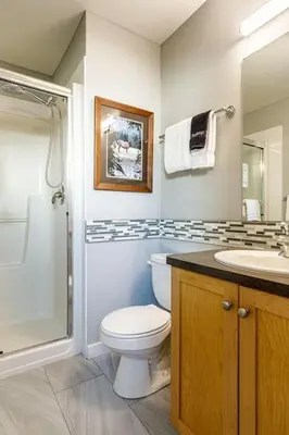 a bathroom with a toilet and a shower and a sink at Mountain Memories Family Fun at The Lodges in Canmore