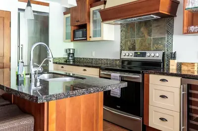 a kitchen with a sink and a stove top oven at Pooches Paradise - Pet Friendly Hot Tub & Pool in Canmore
