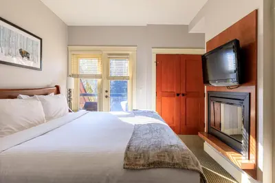 a bedroom with a bed and a flat screen tv at Serene Spruce at Solara Resort in Canmore