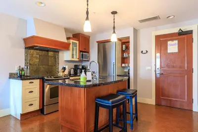 a kitchen with a large island with bar stools at Serene Spruce at Solara Resort in Canmore