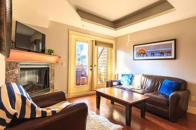 a living room with a couch and a table at Serene Spruce at Solara Resort in Canmore