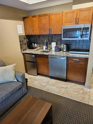 a living room with a couch and a kitchen at Falcon Crest Canmore Banff in Canmore