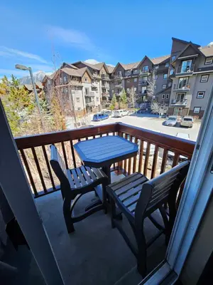 a blue table and chairs on a balcony with a view at Falcon Crest Canmore Banff in Canmore