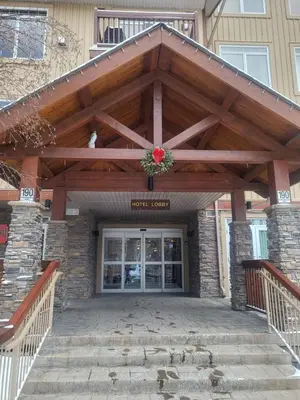 a large wooden pergola over a front door of a house at Falcon Crest Canmore Banff in Canmore