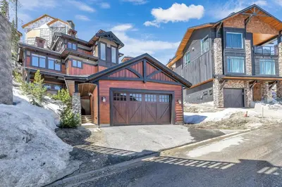 a large house with a garage in front of it at Snow Therapy Chalet - Ski In Out, Hot Tub & Mtn View in Big White