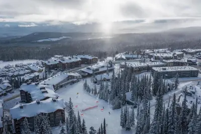 a town covered in snow with trees and buildings at Snow Therapy Chalet - Ski In Out, Hot Tub & Mtn View in Big White