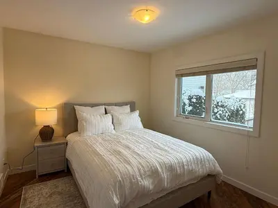 a bedroom with a bed with a lamp and a window at 2Bed Bright & Stylish Ritchie Urban Retreat in Edmonton