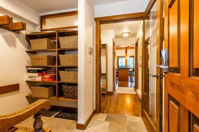 a hallway with a door leading into a room with baskets at Best Location Available in Whistler Village in Whistler