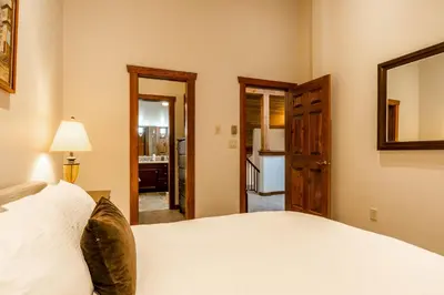 a bedroom with a white bed and a mirror at Best Location Available in Whistler Village in Whistler