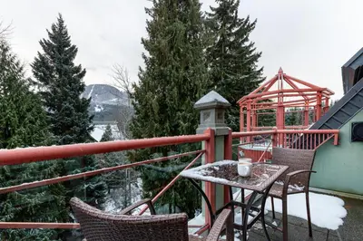 a table and chairs on a balcony in the snow at Village Penthouse w Views Pool and Hot Tub in Whistler