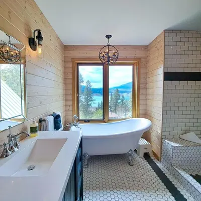 a bathroom with a tub and a sink and a window at Eagle Nest by StayIn in Fairmont Hot Springs