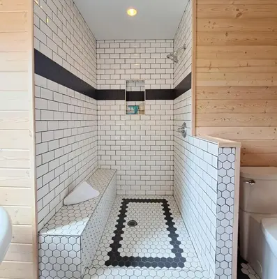 a white tiled bathroom with a tub and a sink at Eagle Nest by StayIn in Fairmont Hot Springs