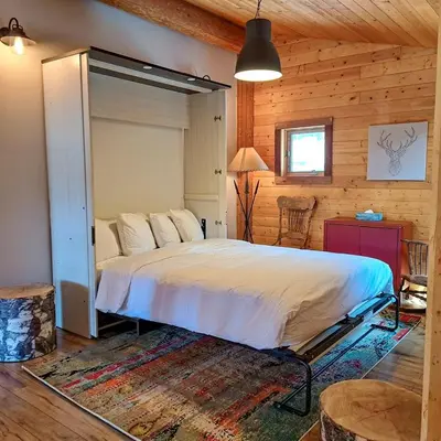 a bedroom with a large bed in a wooden room at Eagle Nest by StayIn in Fairmont Hot Springs